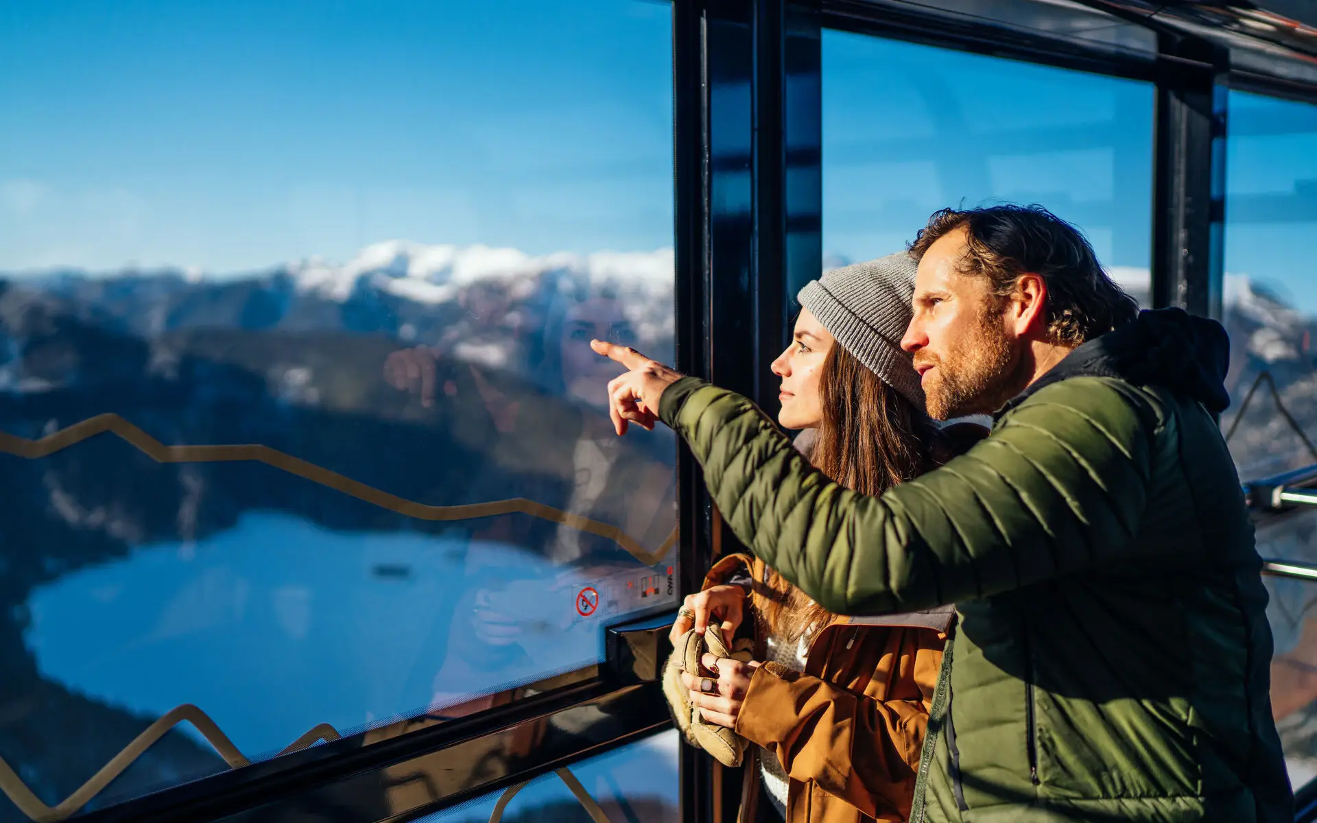 Ein Paar schaut aus dem Fenster auf eine Berglandschaft