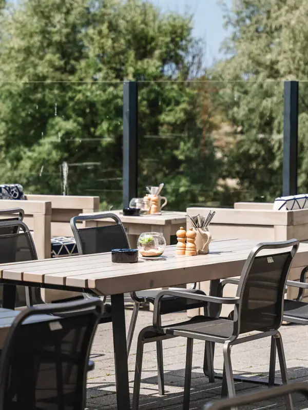 Terrasse im aja Warnemünde Ein Tisch und Stühle auf einer Terrasse.