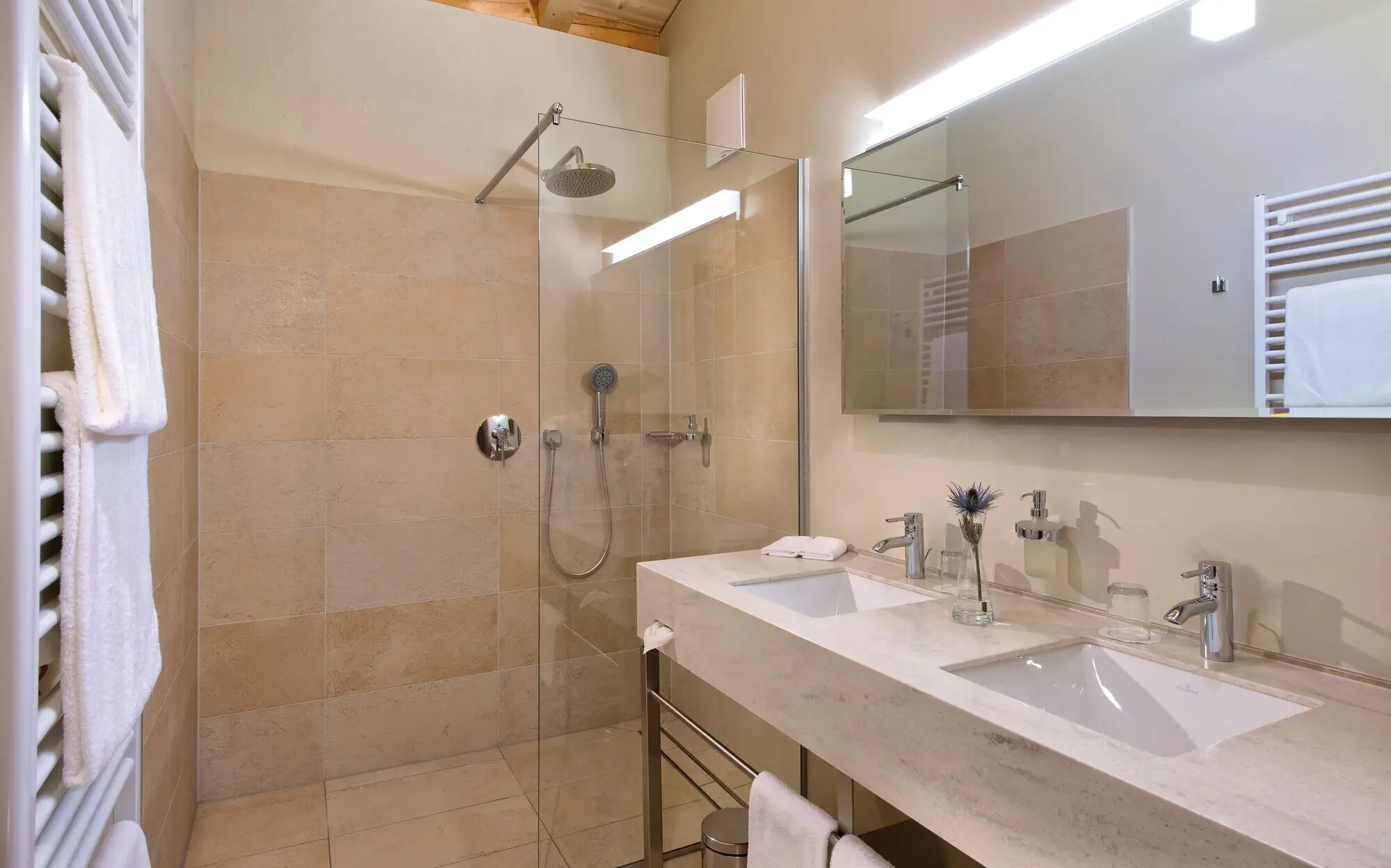 Interior view of a bathroom with shower and washbasin, fitted with tiles and modern sanitary facilities.