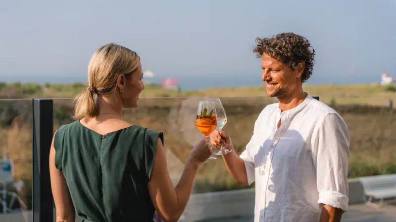 Anstoßen Ein Mann und eine Frau halten Weingläser.