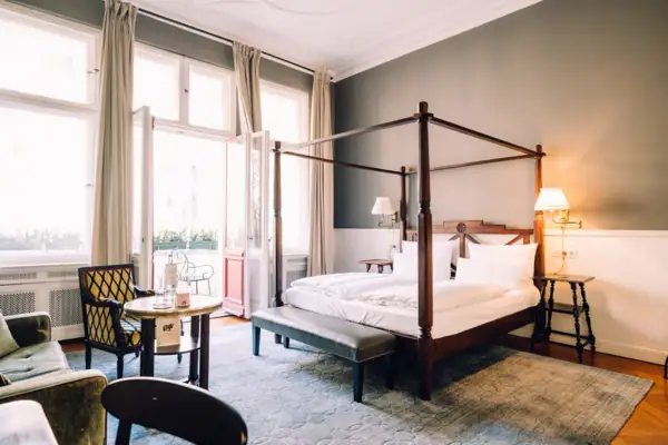 Ein Zimmer mit einem Himmelbett und einem Tisch.