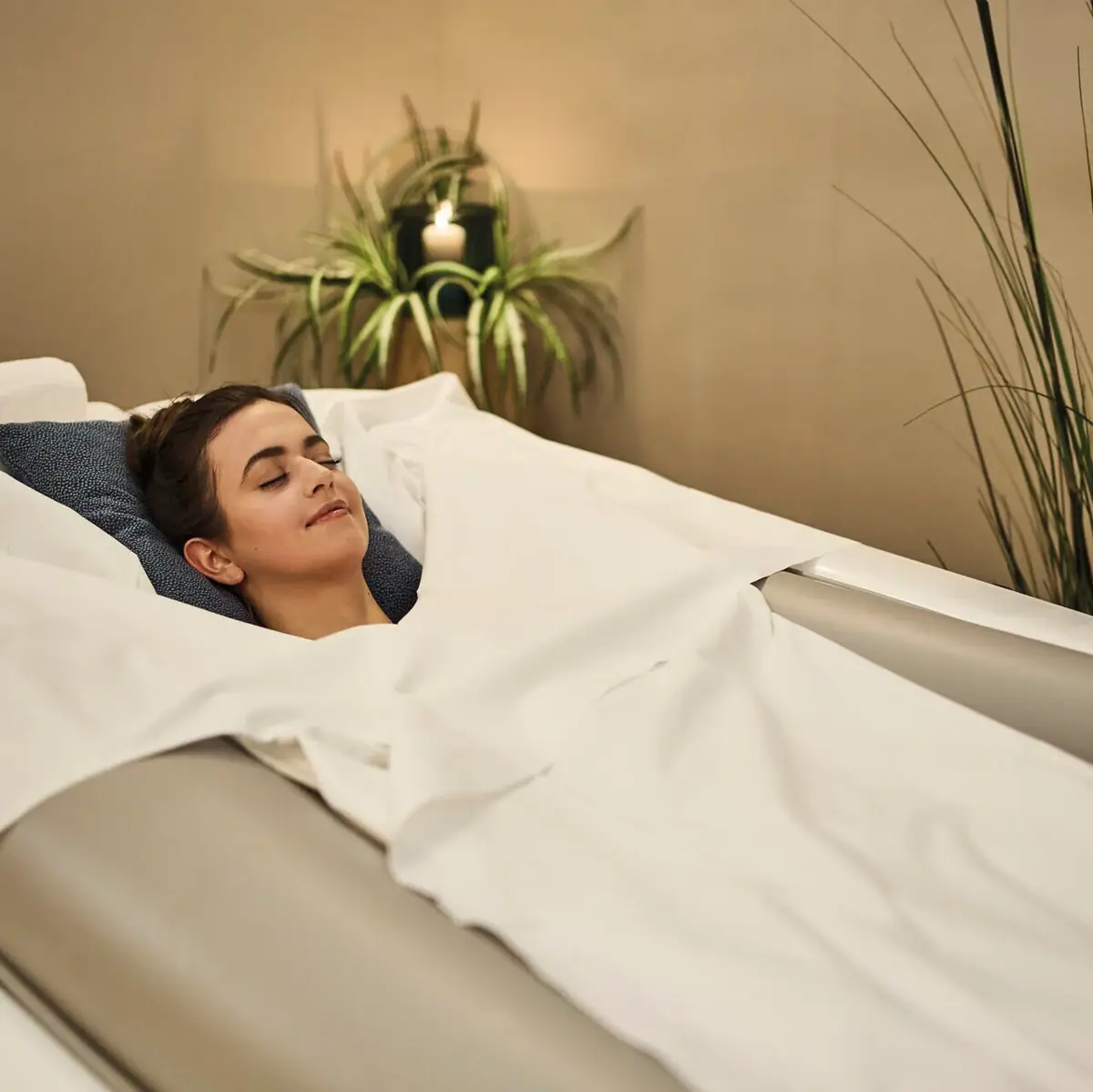 Eine Frau liegt in einem Bett auf einer Softpackliege