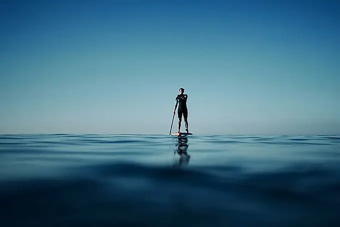 Eine Person auf einem Paddleboard im Ozean.