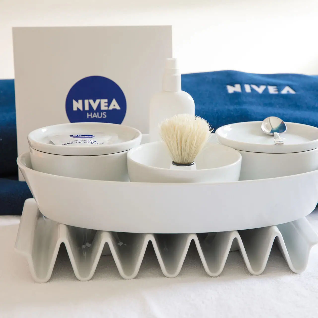 Eine weiße Schüssel mit einem Pinsel und eine Schüssel mit einem Löffel auf einer weißen Fläche.