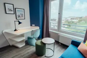 Ein Raum mit einem Tisch, einem Stuhl und einem Fenster.