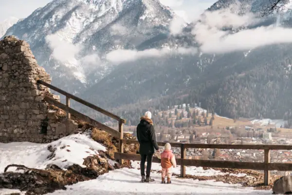 Eine Frau und ein Kind stehen auf einem verschneiten Berg.
