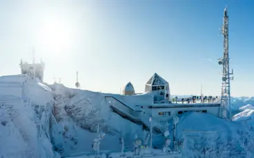 Ein Gebäude mit einer Treppe auf einem verschneiten Berg.