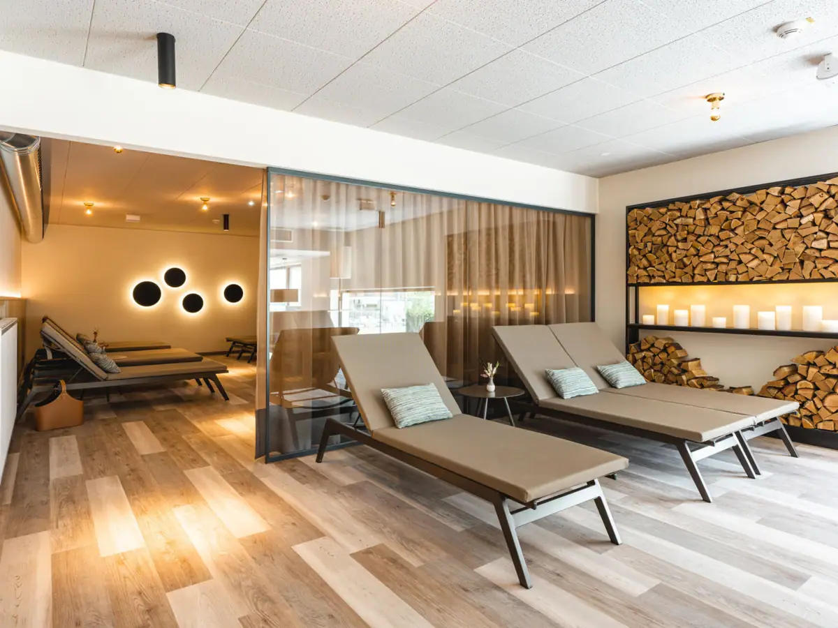 Ein Raum mit Lounge-Sesseln und Holzregalen.