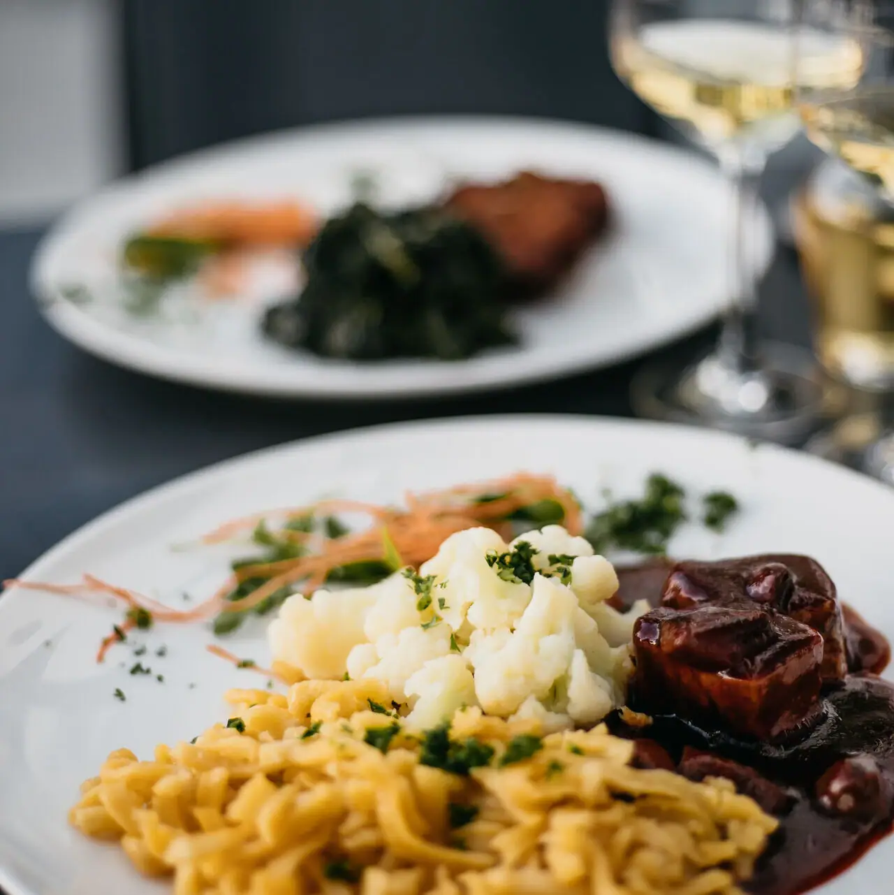 Spätzle Ein Teller mit Essen auf einem Tisch.