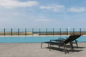 Ein Pool mit Stühlen und einer Fahne an der Seite.