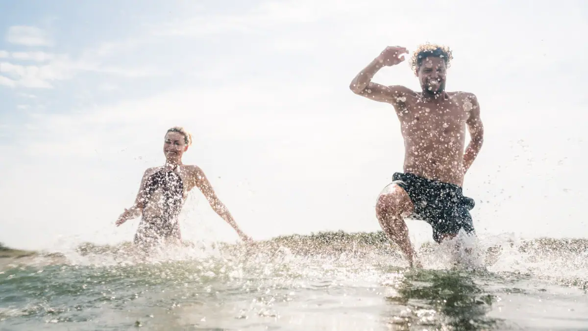Zwei Personen laufen im Wasser.