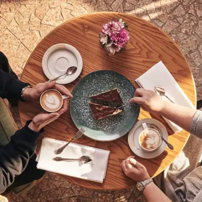 Café Nordstrand Zwei Menschen sitzt an einem Tisch mit Kaffee und Kuchen.
