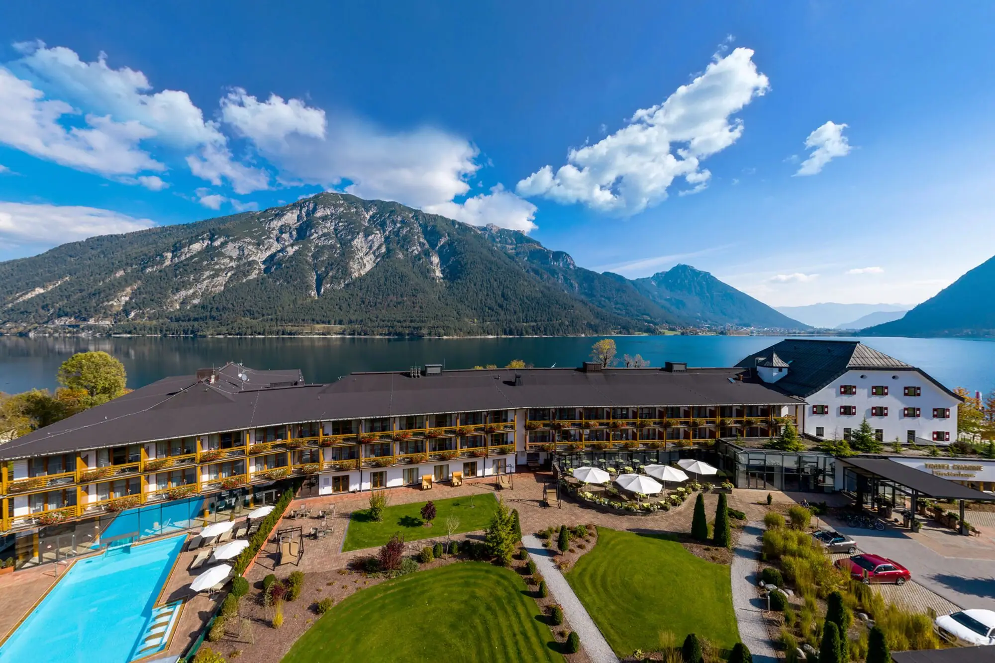 Ein Gebäude mit Pool und Rasenflächen an einem See.