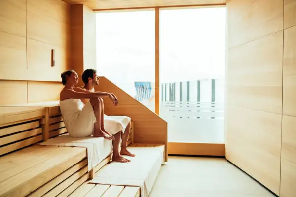 Sauna Ein Mann und eine Frau sitzen auf einer Bank in einer Sauna.