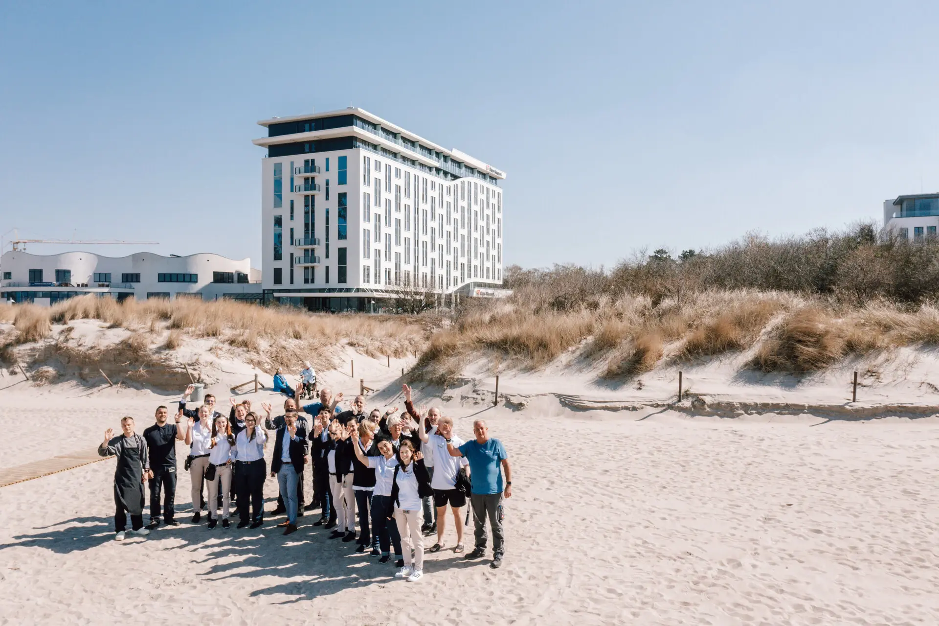 Teamfoto Eine Gruppe von Menschen posiert vor einem Gebäude.