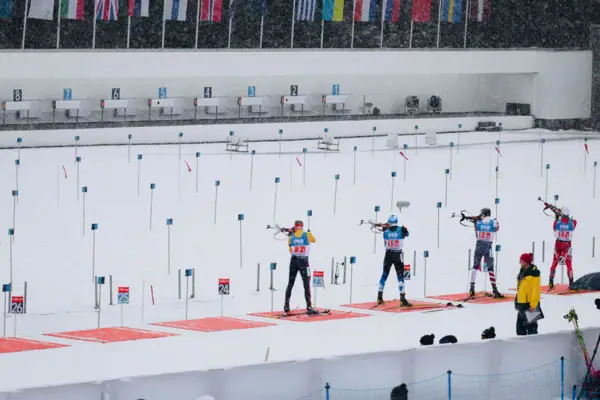 Eine Gruppe von Menschen in Biathlon-Ausrüstung im Schnee.
