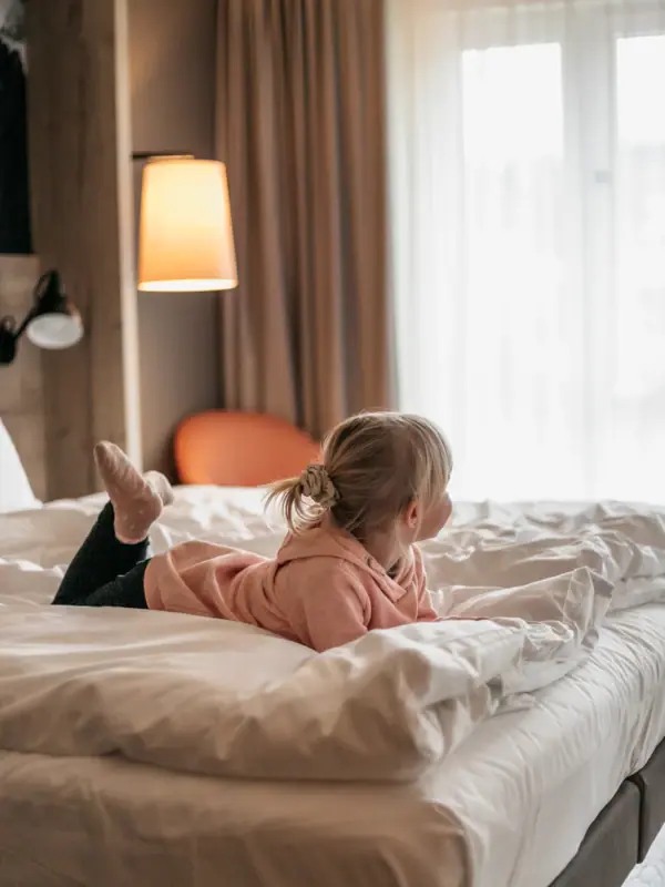 Ein Kind liegt auf einem Bett in einem aja Familienhotel in Bayern.