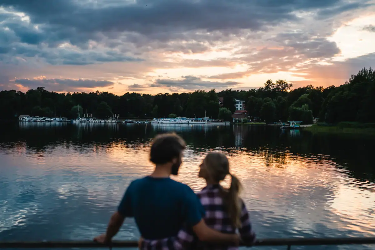 Ein Mann und eine Frau stehen an einem Gewässer.