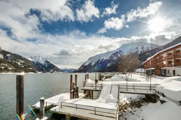 Ein schneebedeckter Steg an einem See.