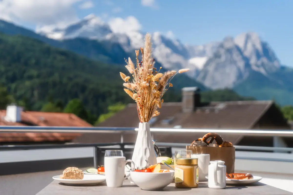 Frühstück Ein Tisch mit Essen und einer Vase mit Weizen darauf.