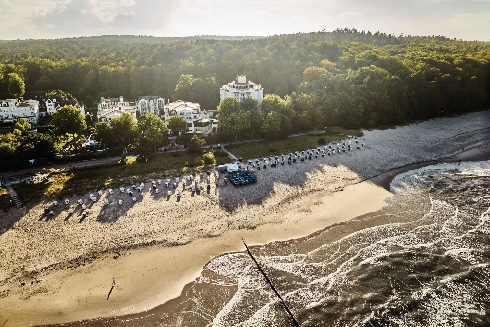 Gruppe von Strandkörben an einem Strand mit Bäumen.