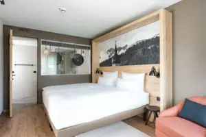 Suite Bergblick Ein Bett mit einem Bild darüber.