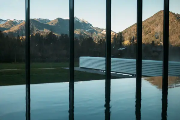 Große Glaswand mit Blick auf Berge und Gras.