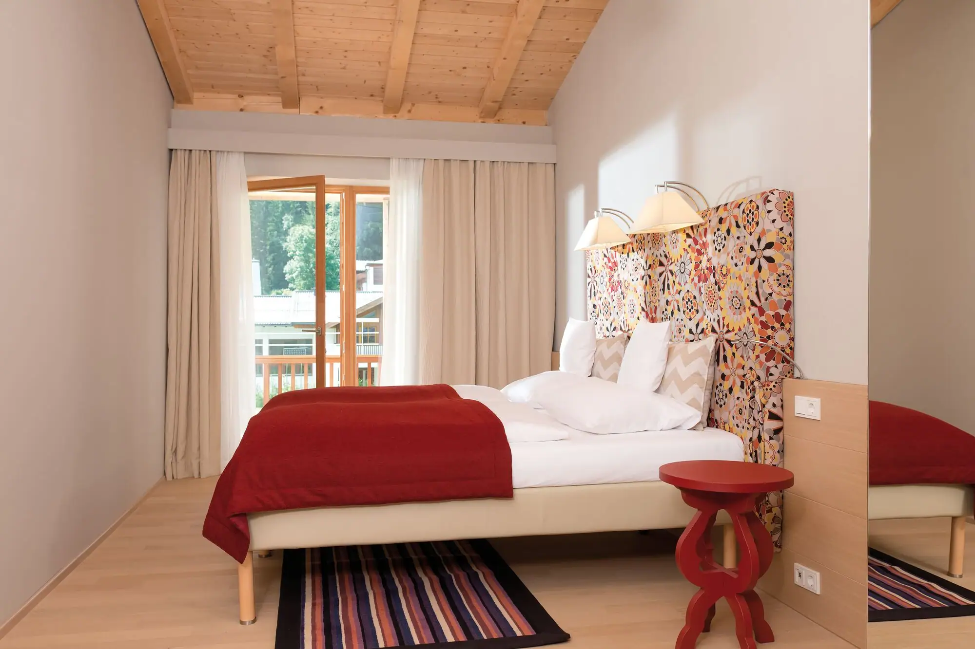 Schlafzimmer Ferienwohnung Bett mit buntem Kopfteil in einem Zimmer