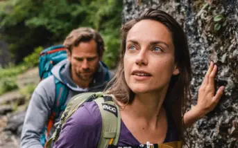 Ein Mann und eine Frau beim Wandern an einem Felsen.