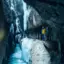 Zwei Menschen stehen in der Partnachklamm und betrachten die winterliche Schlucht mit Eiszapfen.