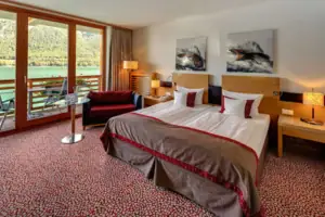 Doppelzimmer Ein Schlafzimmer mit einem Bett, einem Stuhl und einem Tisch.