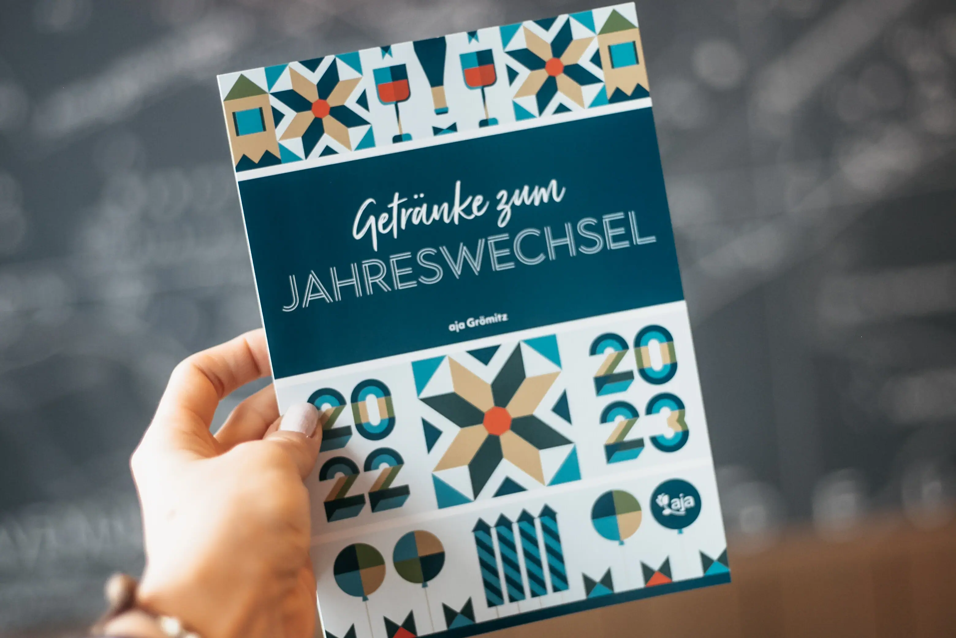 Hand hält ein Programmheft mit handschriftlichen Notizen.