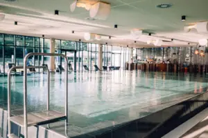 Großes Hallenschwimmbad mit klarem Wasser und moderner Architektur.