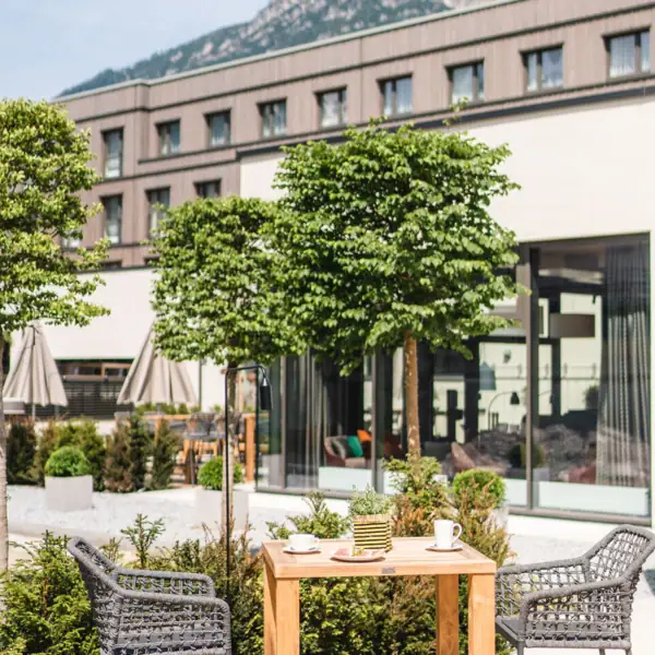 Terrasse Ein Tisch und Stühle draußen vor einem Gebäude.