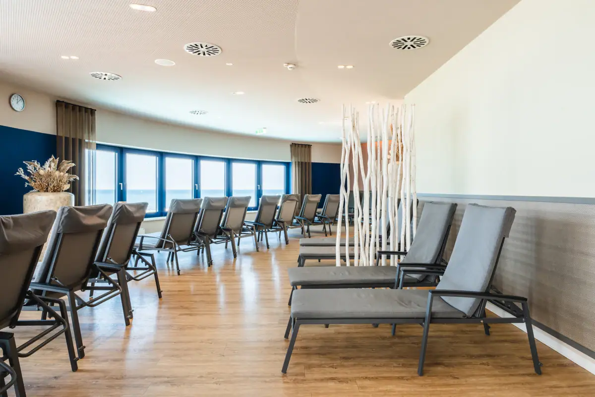 Ein Raum mit Liegen und Fenstern.