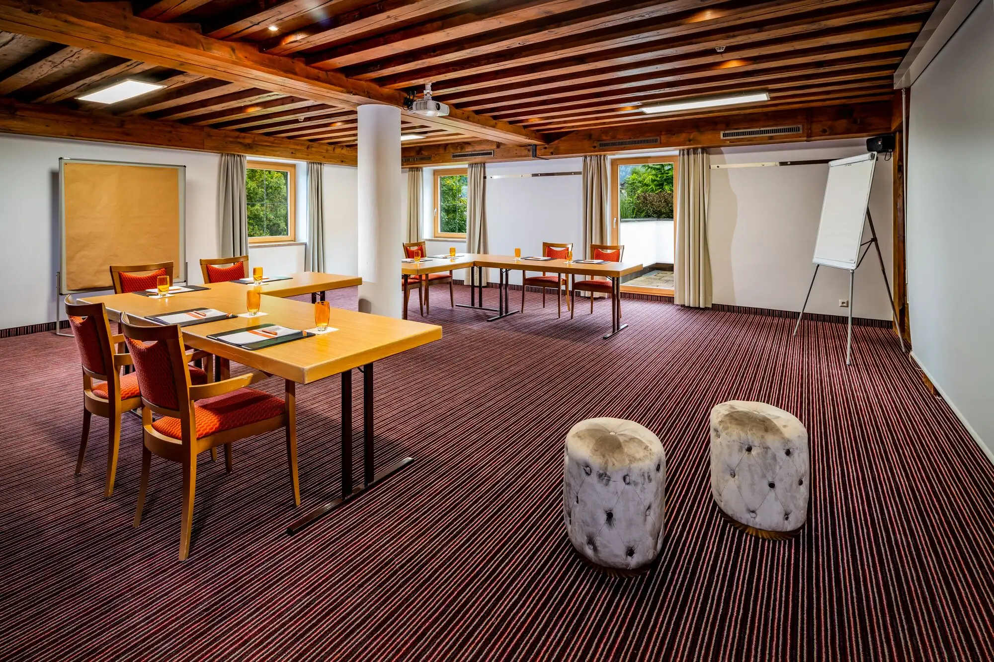 Raum Maximilian Ein Raum mit Tischen und Stühlen.