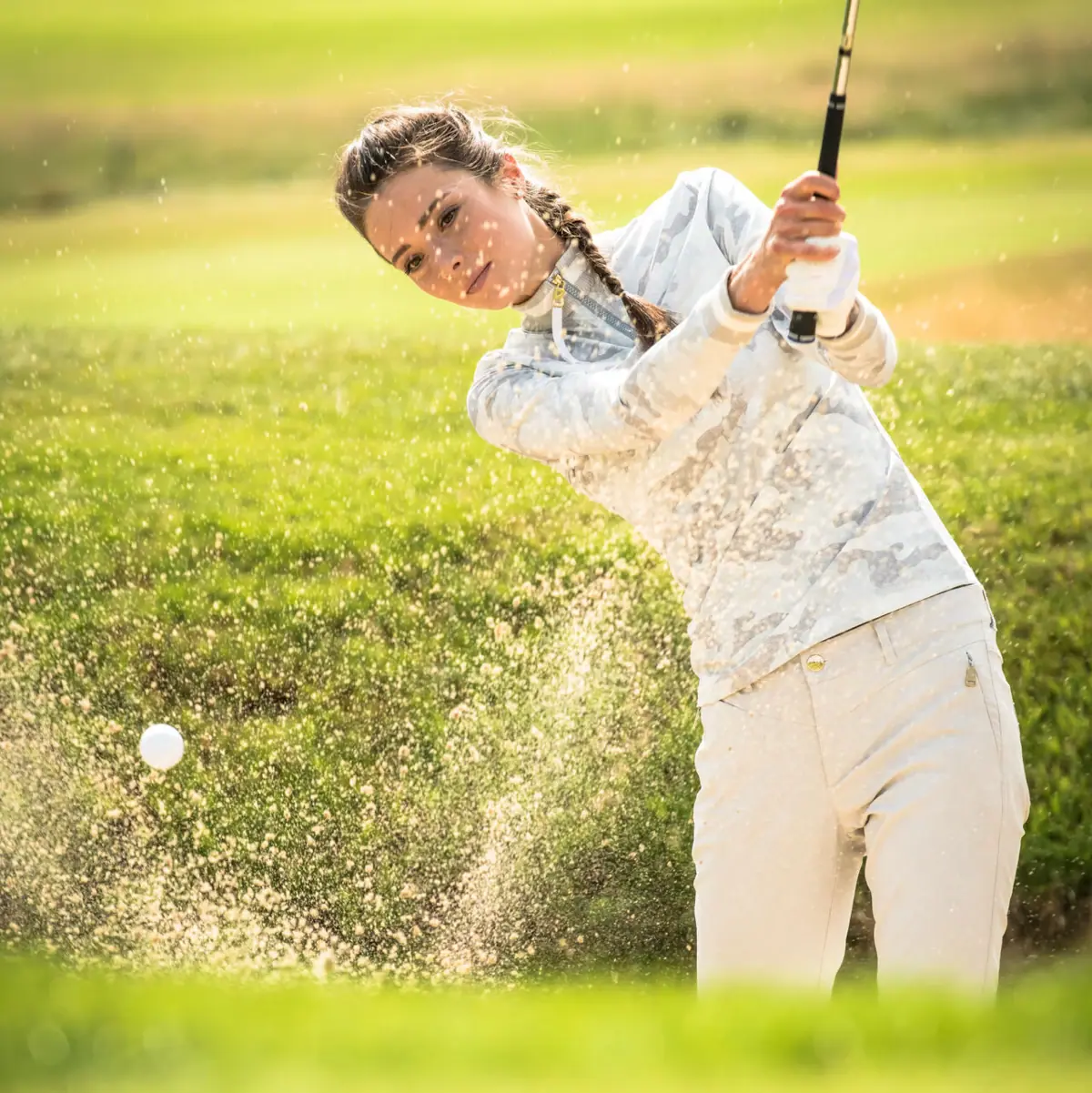Eine Frau schwingt einen Golfschläger auf einem Golfplatz in Ruhpolding.