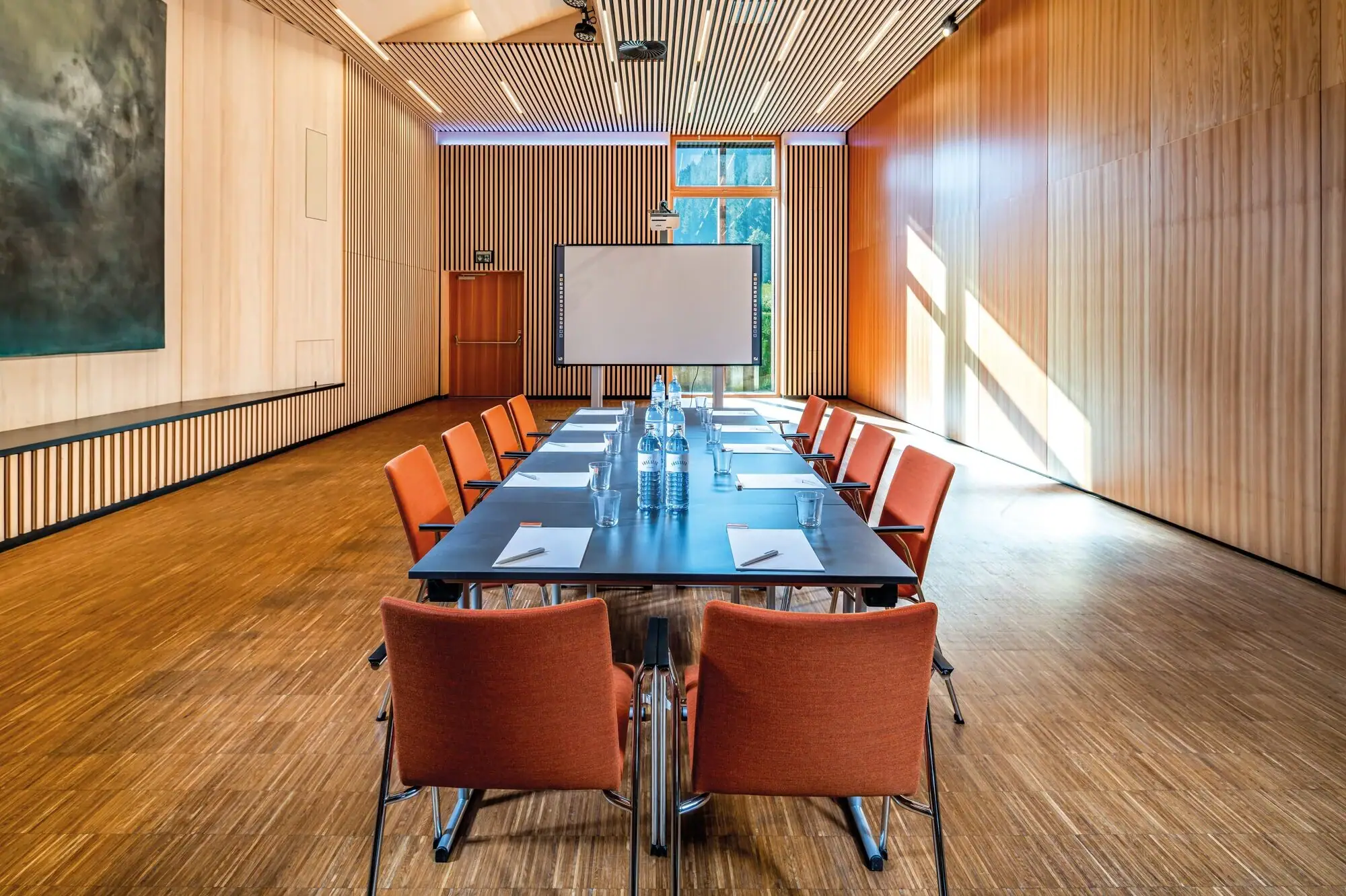 Konferenzraum mit Tisch und Stühlen.