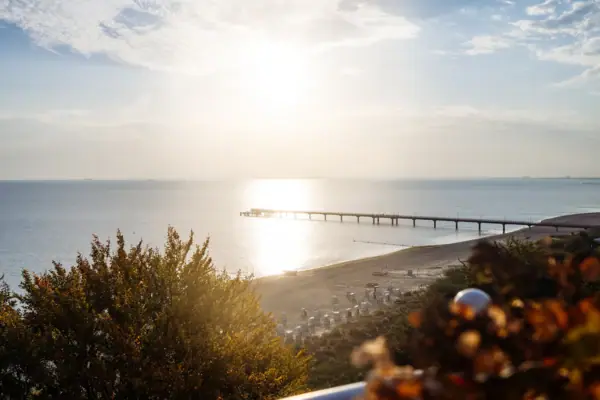 Strand Ein Pier am Strand unter einem bewölkten Himmel.