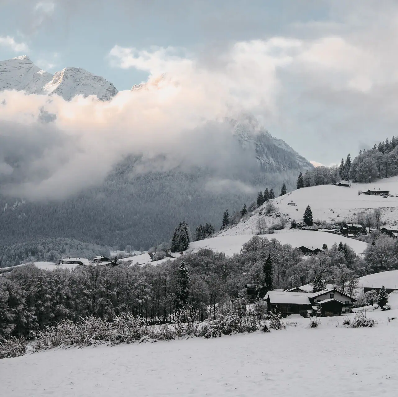 Verschneite Landschaft mit Bergen und Häusern in Ruhpolding.