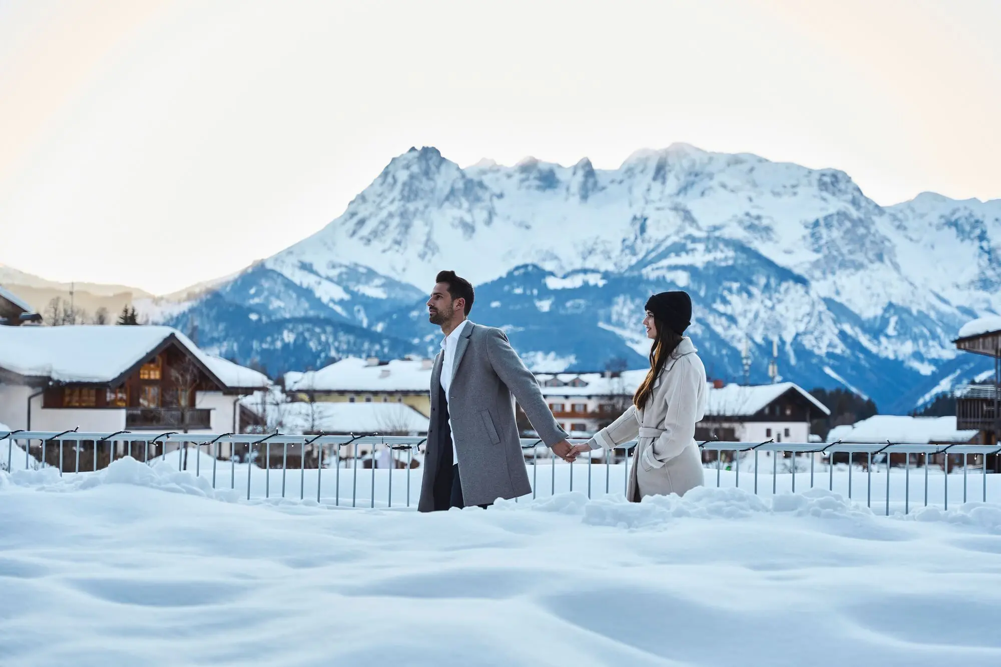 Ein Mann und eine Frau halten Hände im Schnee.