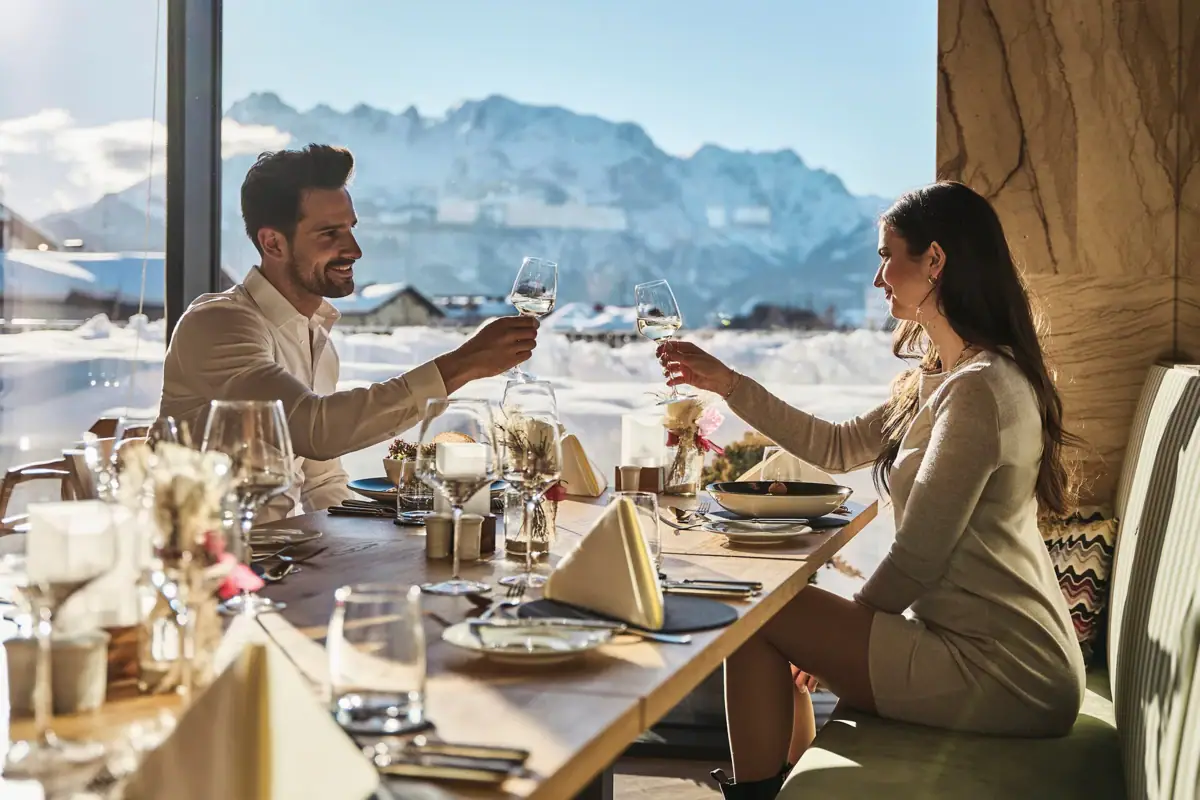 Restaurant Werfenweng Ein Mann und eine Frau sitzen an einem Tisch mit Weingläsern.