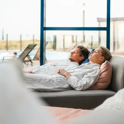 Ein Mann und eine Frau liegen auf einem Sofa.