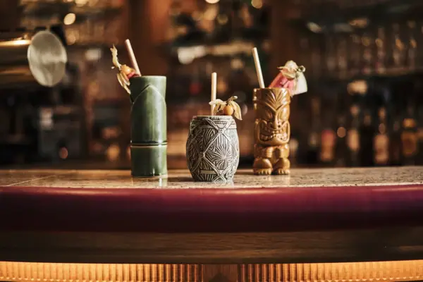 Eine Gruppe von Tiki-Bechern auf einem Tisch.