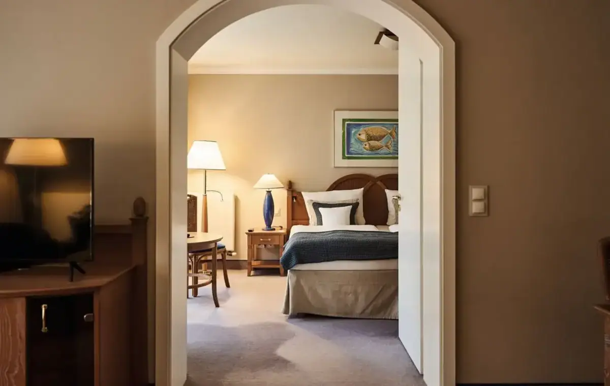 Senior-Suite  Schlafzimmer mit Bett, Nachttisch und Lampe.