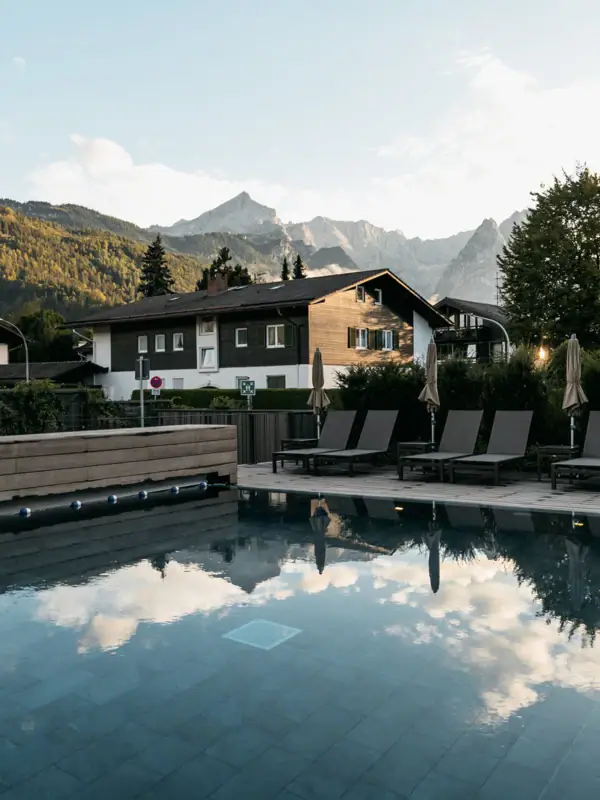 Ein Pool mit Stühlen und einem Gebäude im Hintergrund.