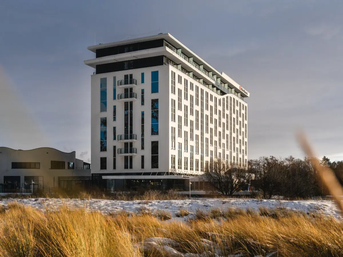 aja Warnemünde Hohes Gras und ein Gebäude im Schnee