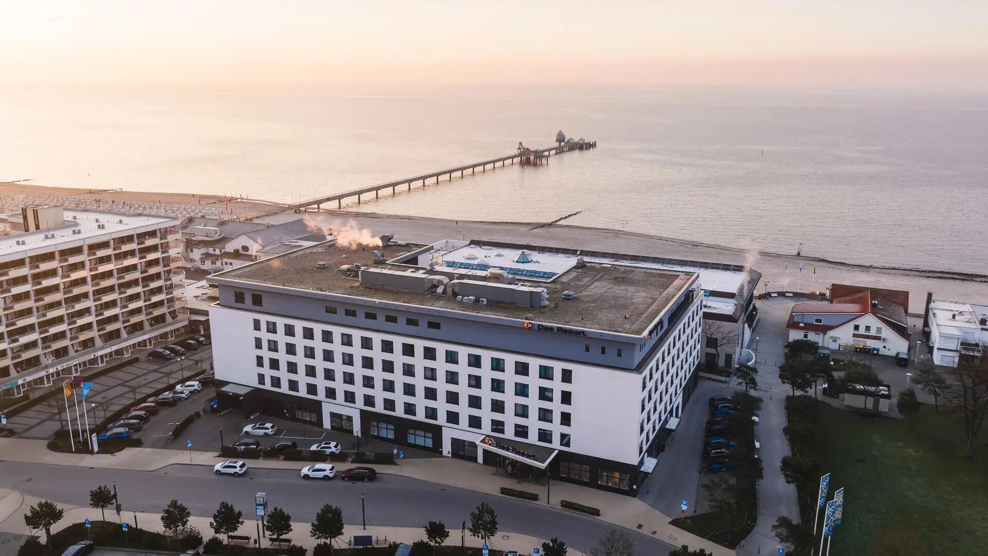 aja Grömitz Außenansicht von oben mit einer Drohne aufgenommen mit direkter Strandlage und der Ostsee im Hintergrund.