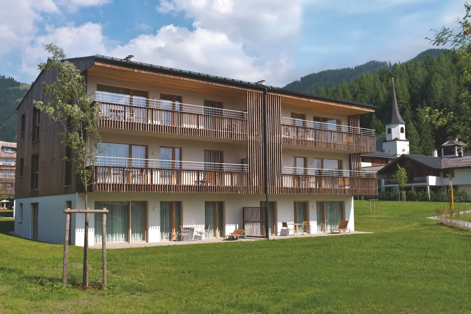 Vacation apartments in Werfenweng with lawn and trees in the background.