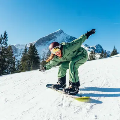 Eine Person auf einem Snowboard.